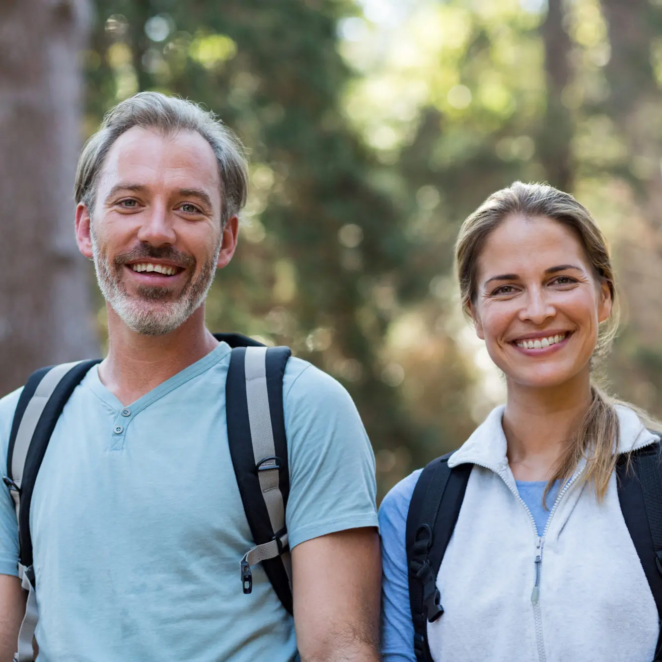 Smiling middle-aged couple hiking outdoors