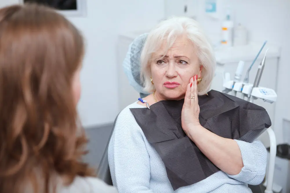 elderly woman suffering from toothache visiting dentist