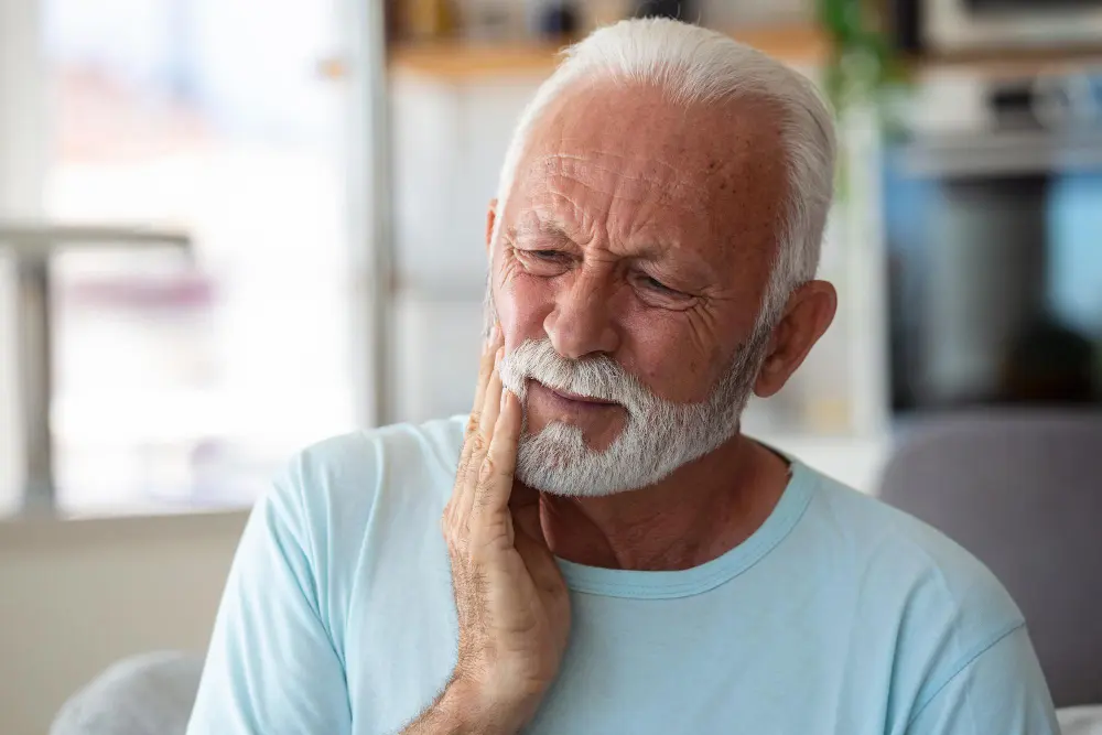 Older man holding jaw in pain